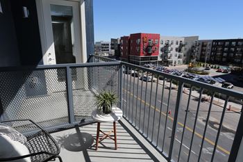 Private balcony overlooking city street, small table and plant on balcony